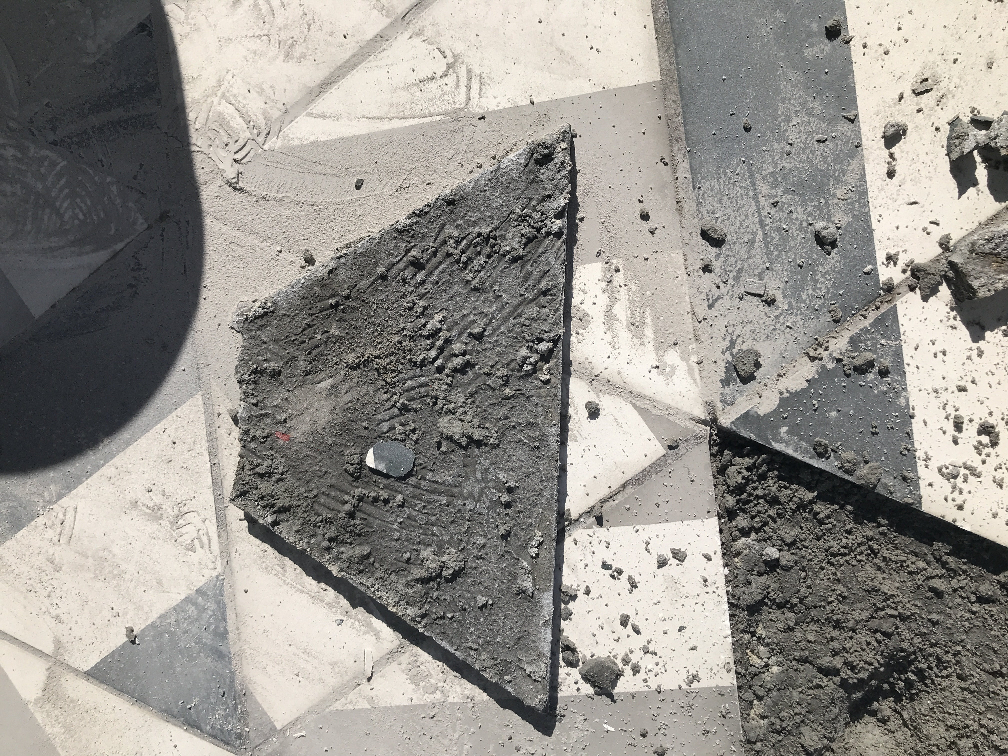 Removed concrete pool deck tile revealing deficient mortar coverage and spot bonding pattern on hotel installation