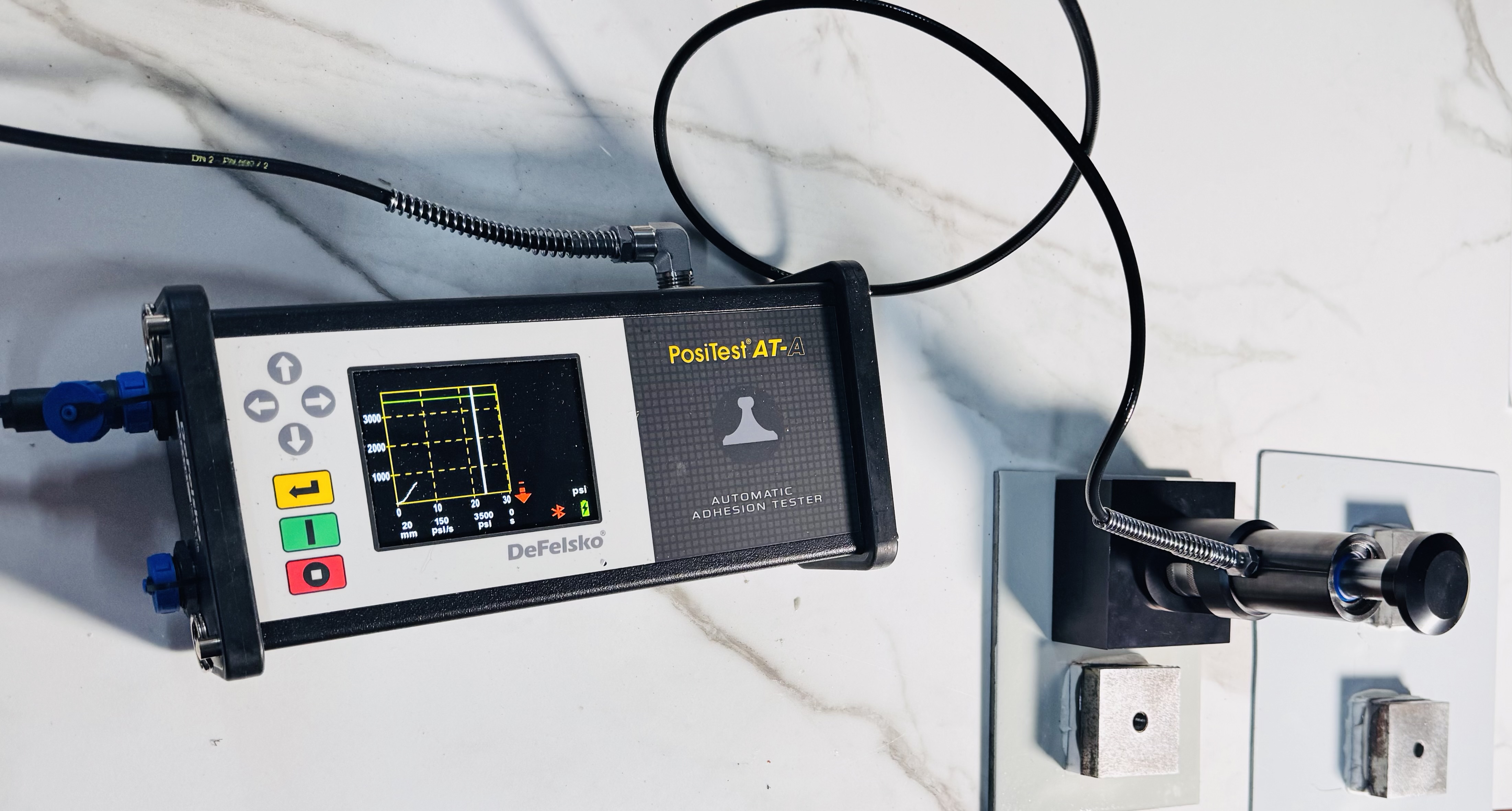 PosiTest AT-A adhesion tester measuring bond strength on marble tile installation